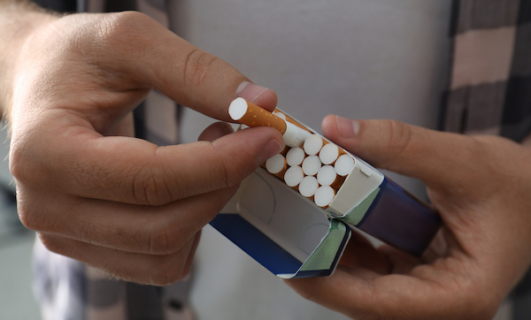 Man taking cigarette out of pack, closeup