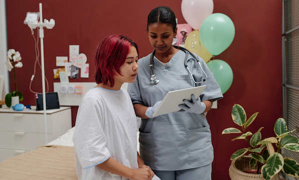 Confident plastic surgeon in uniform and protective gloves making presentation