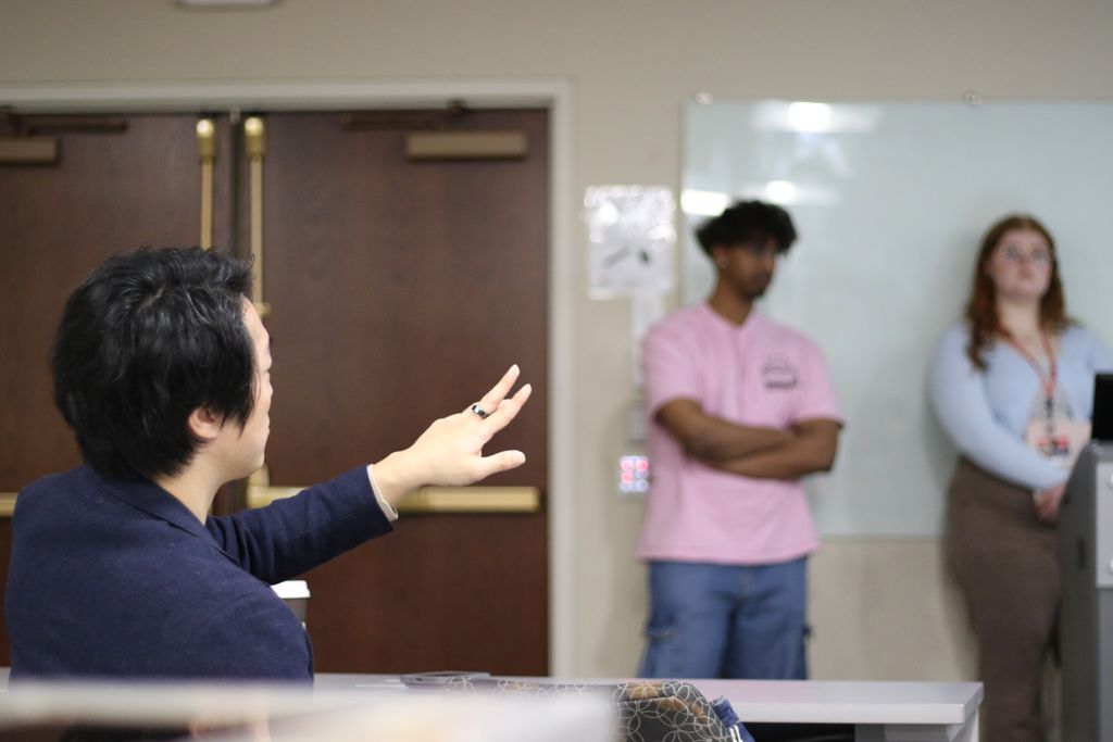 Koichiro日本柴, assistant professor of epidemiology, gives student presenters feedback.