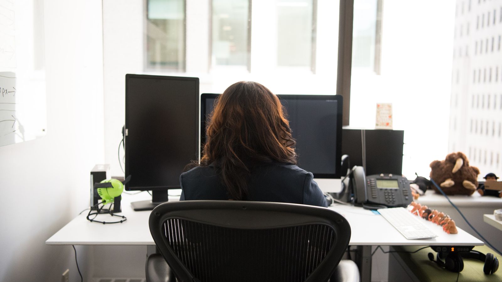 woman-sits-at-desk-facing-window