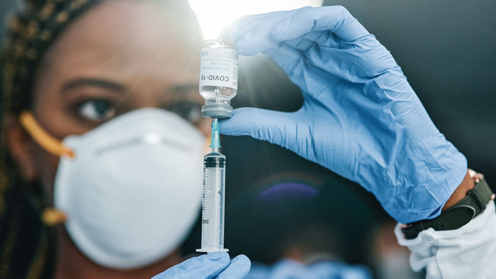 Photo of a young nurse holding a vaccine at work in a modern office