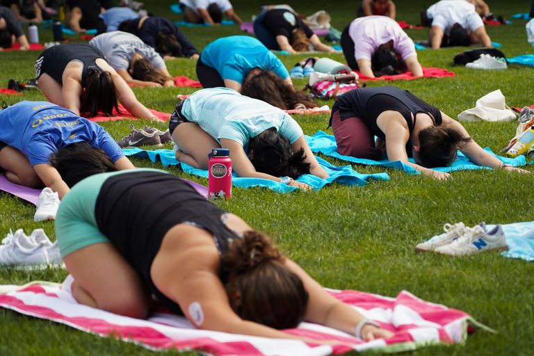 Students participate in a yoga class at BU Beach, part of Boston University's Charles River campus.