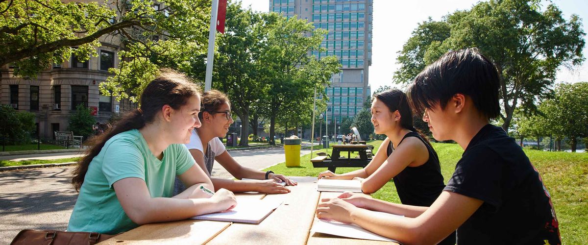 A group of BU Summer Term students sitting at a picnic bench outdoors