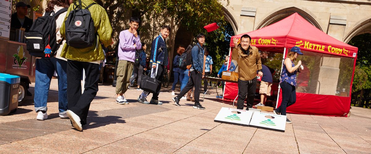 Students gathered around a bean toss game at the sustainability festival.