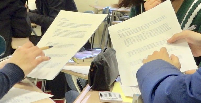 Two students work on handouts together in class