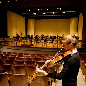 Student tuning before a BU Symphony Orchestra rehearsal