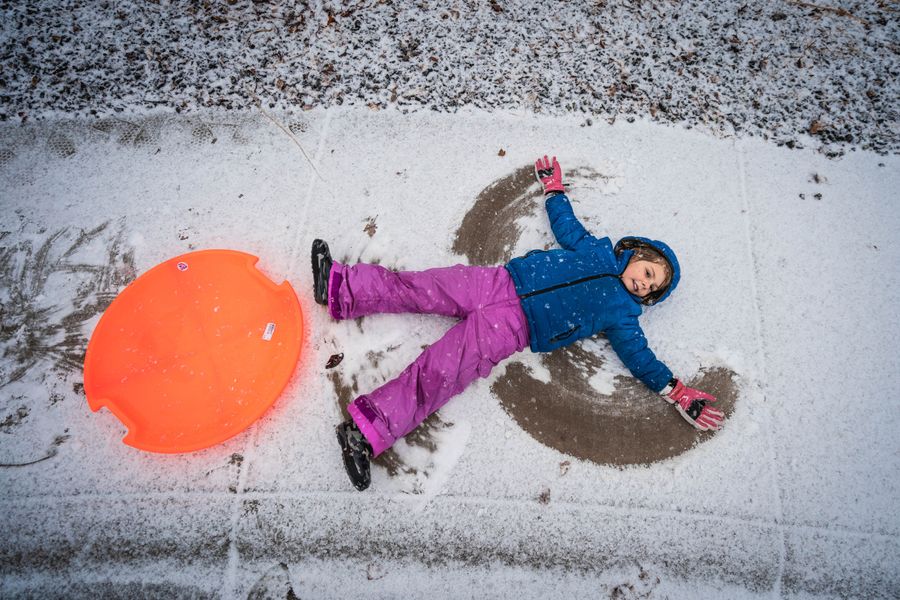 Young girl creating a snow angel
