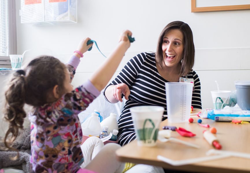 Child Therapist plays with young girl in hospital