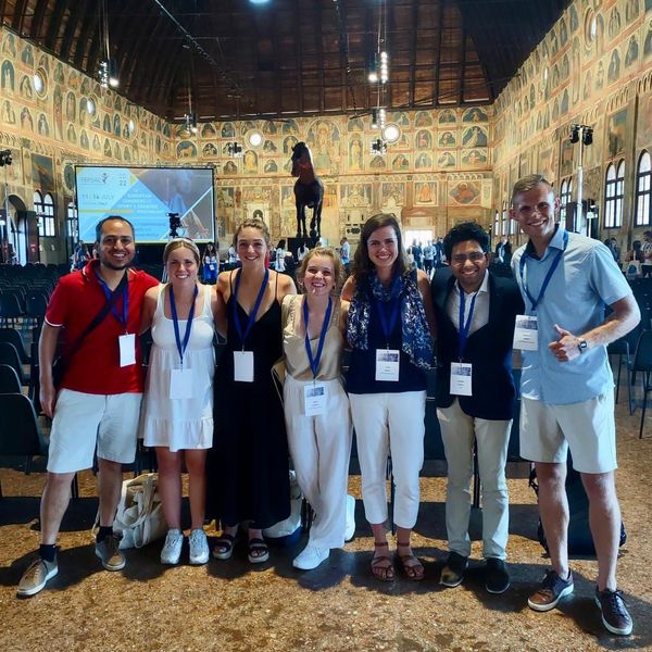 Shows professor and six graduate students at conference