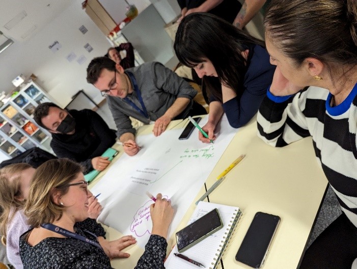 Shows five teachers working at a table