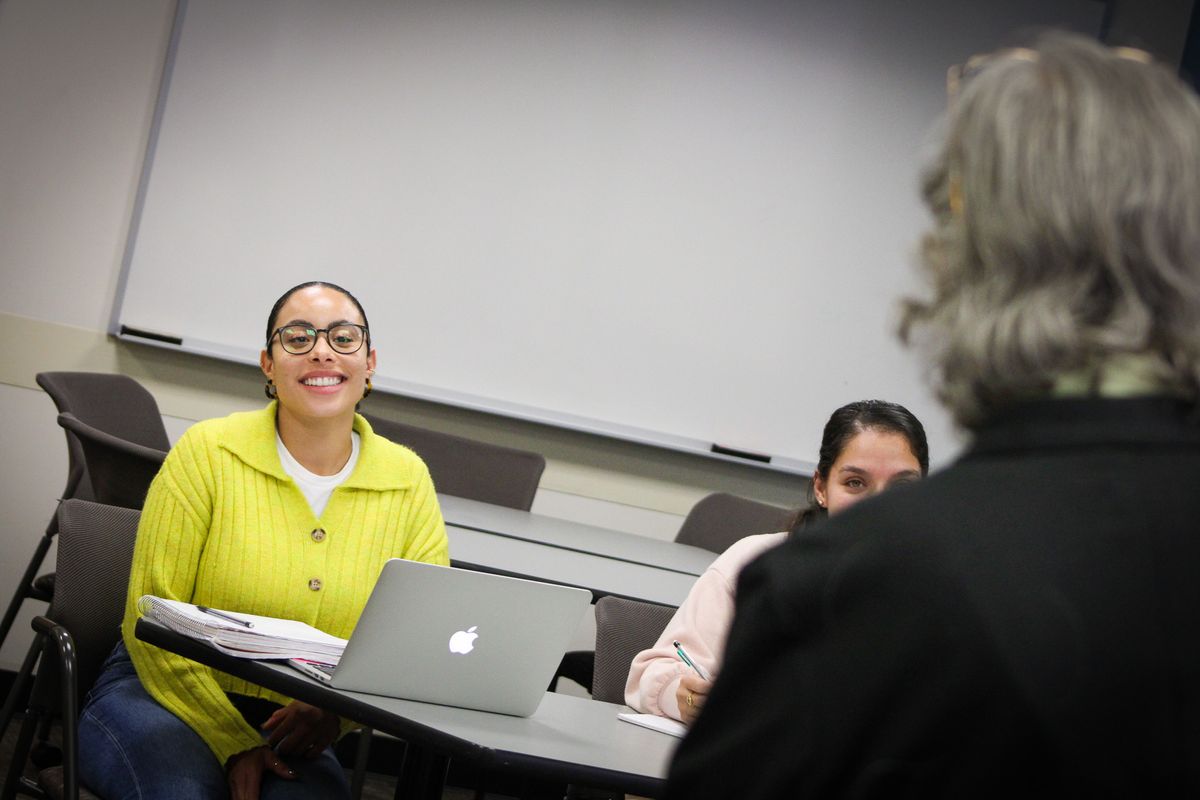 Student smiling looking towards faculty