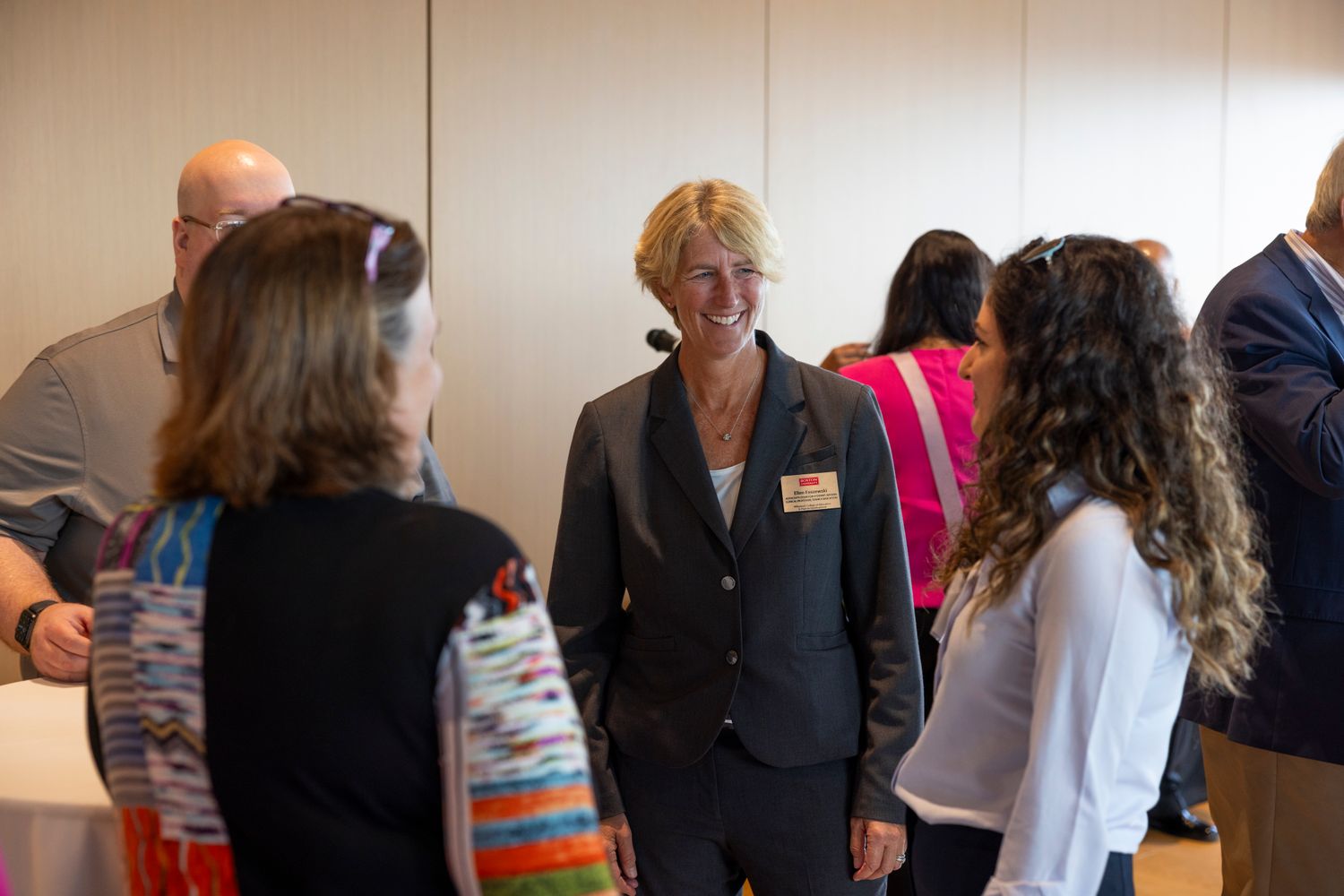Ellen Faszewski smiling speaking with Leslie Dietiker and hsan Ghazal