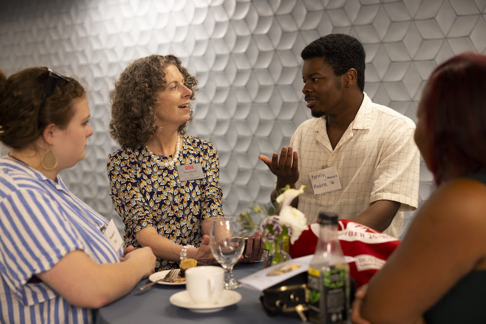 Penny Bishop speaking with alums over tea