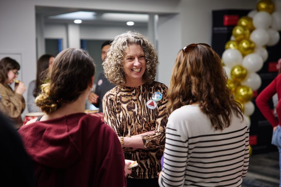Dean Penny Bishop smiling talking with two BU Wheelock Community members