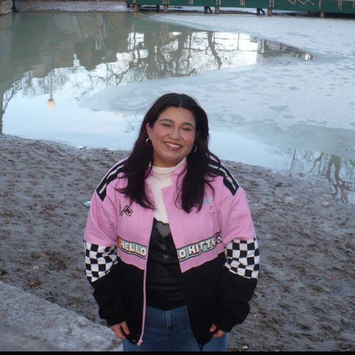 Alondra Hernandez in pink and black jacket smiling outside