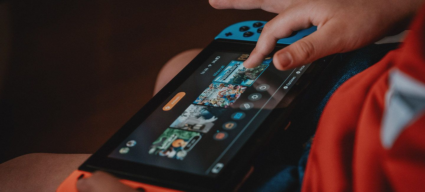 Child playing with Nintendo Switch gaming device.