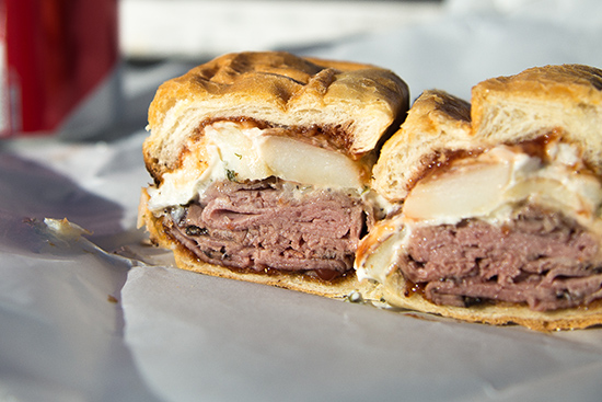 Roast beef sandwich cut in half on a plate