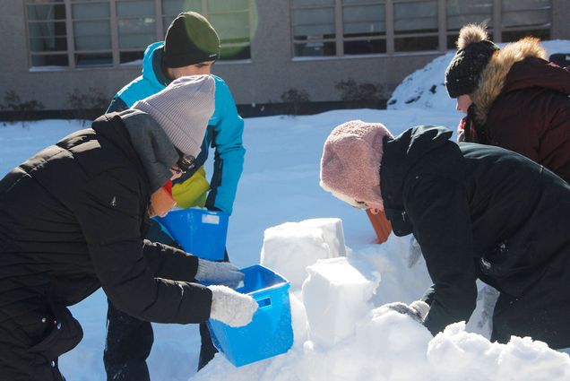 Photo taken of a group of Boston University students after the snow storm on January 29 building a snow castle with a blue bucket. Photo by Siyi Yang (COM’22)