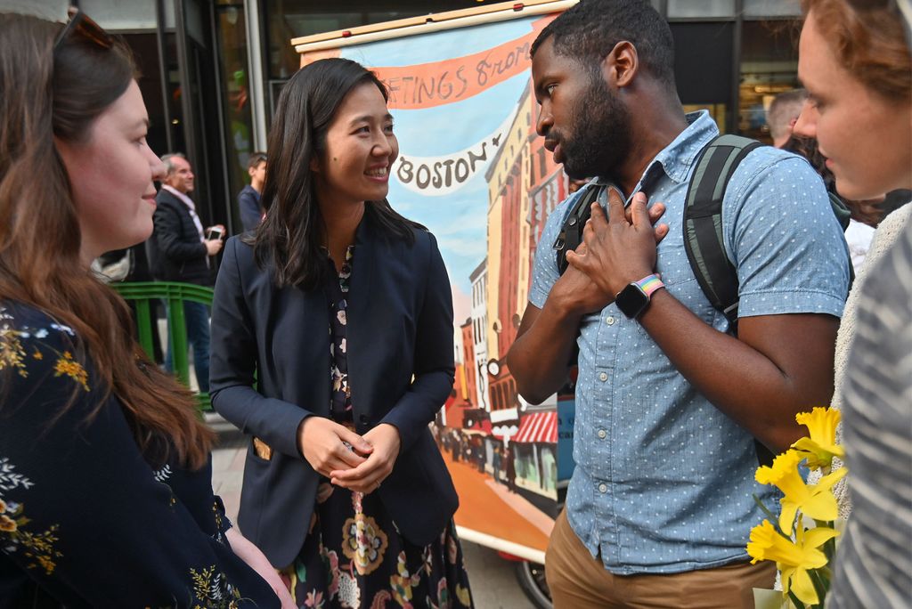 Boston Mayor Michelle Wu and a group of supporters have a quick discussion on an overcast day in MA