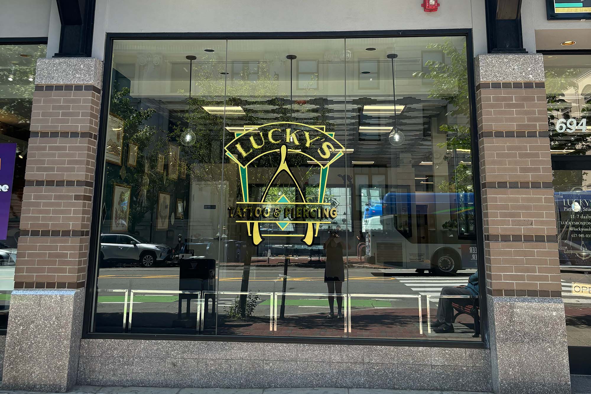 Photo: The exterior of Lucky's Tattoo and Piercing with a golden wishbone logo on the window