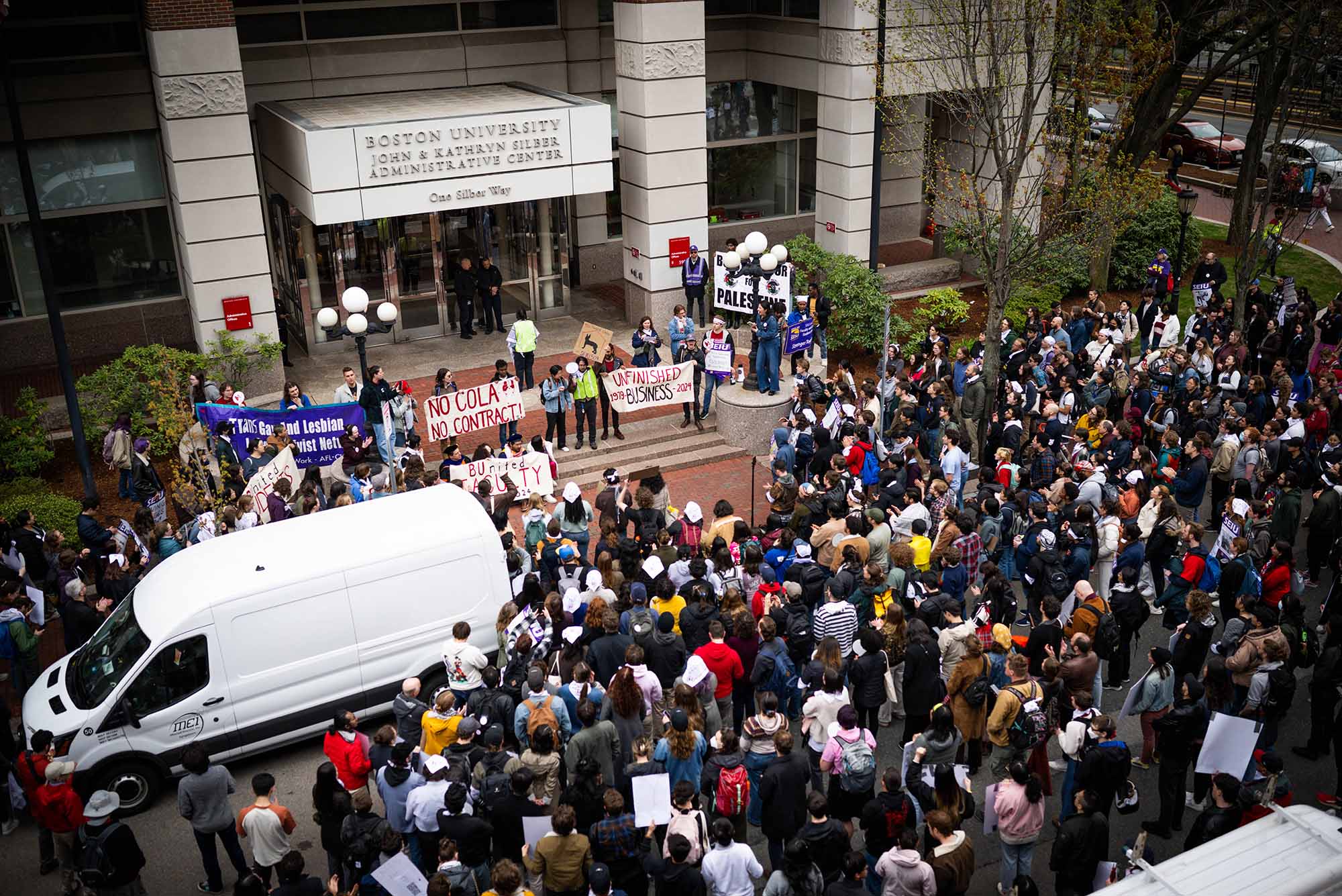 Photo: A crowd of many people gathered in front of an academic building