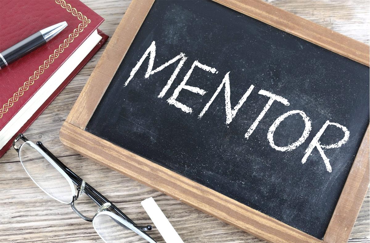 Photo of tabletop chalkboard with "MENTOR" written in white chalk