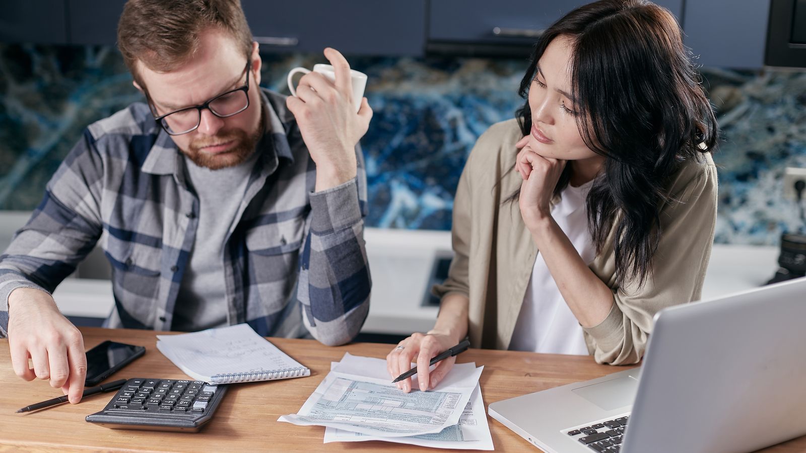 man and woman work on their taxes