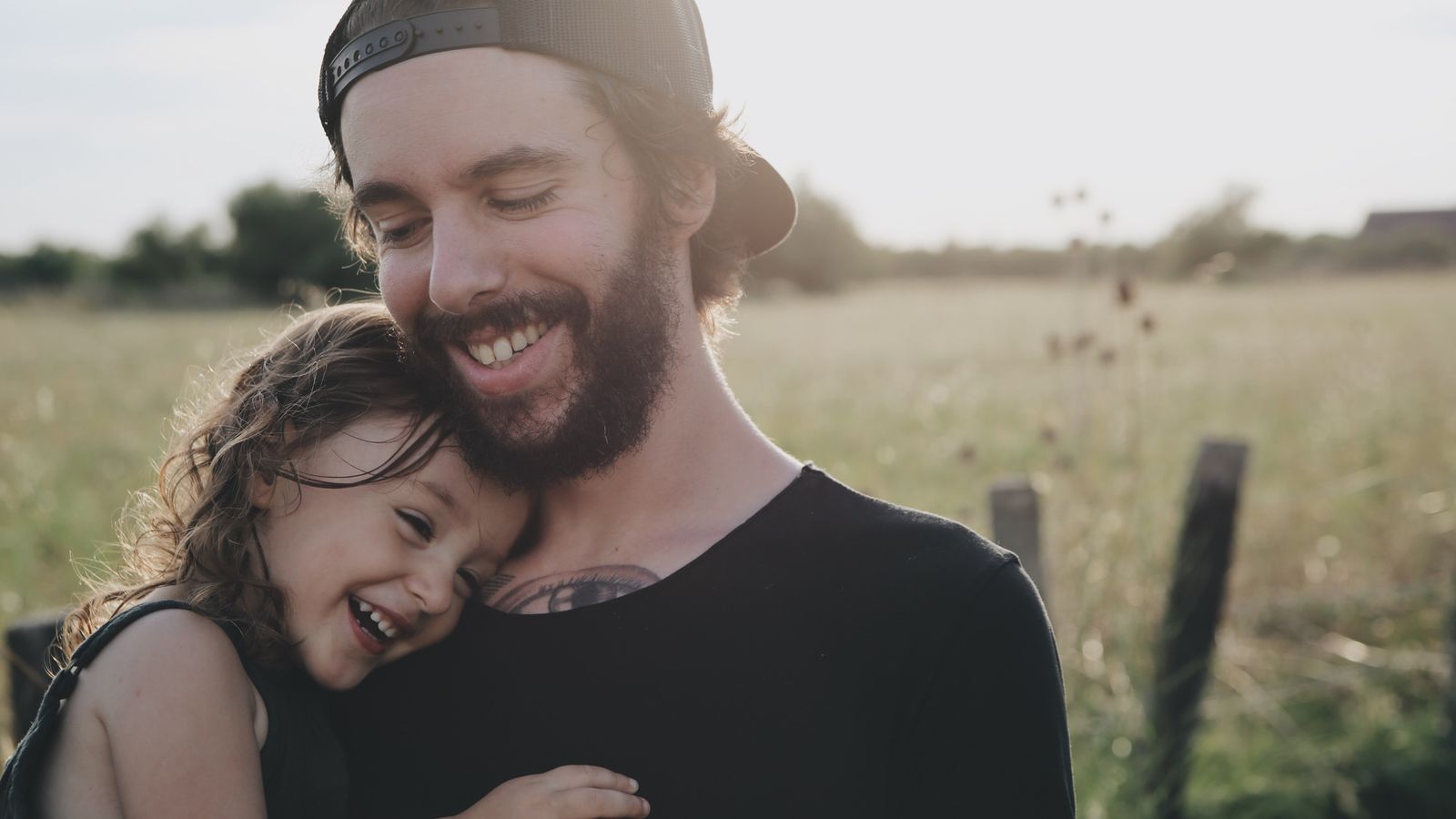 Smiling father and daughter outside in a field