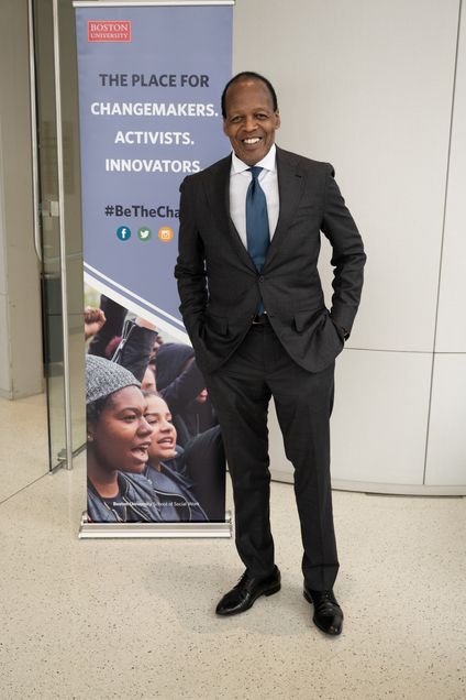 Featured speaker Lee Pelton standing by pop up banner reading "Boston University, the place for changemakers, activists, innovators, #BeTheChange