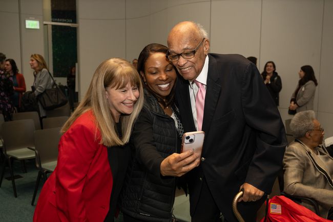 2 speakers and event guest smile for selfie